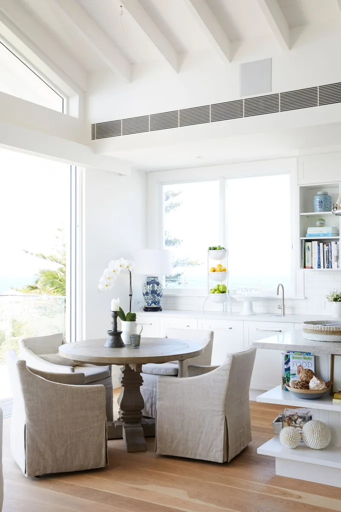 The dining nook at Deborah Hutton's bronte home with rattan dining lounges and a small circular table