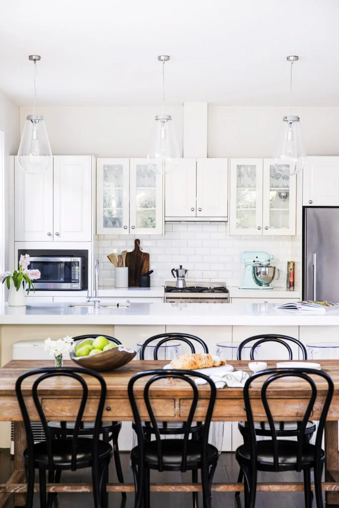 Open plan dining and kitchen with white shaker-style cabinets.