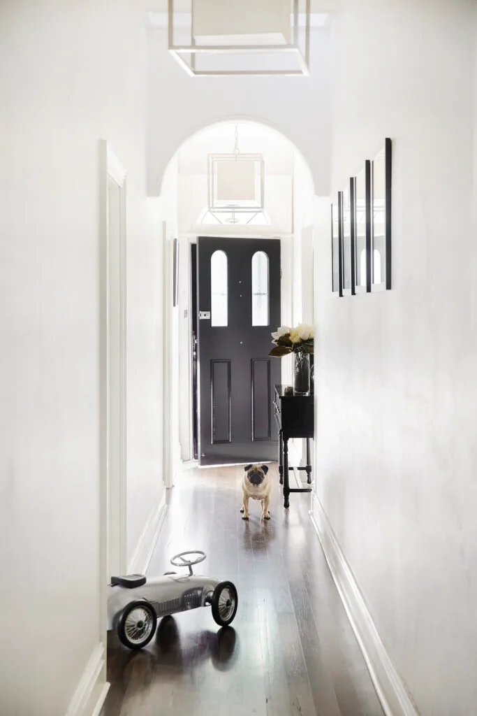 Hallway of a terrace home in Sydney's inner west featuring a black front door.