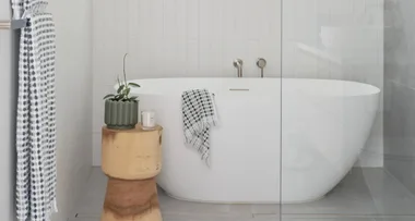 White freestanding bathtub in a contemporary bathroom with a neutral, white and grey colour palette.