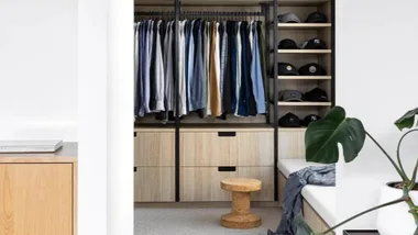 Organised walk in wardrobe with open shelving and timber drawers