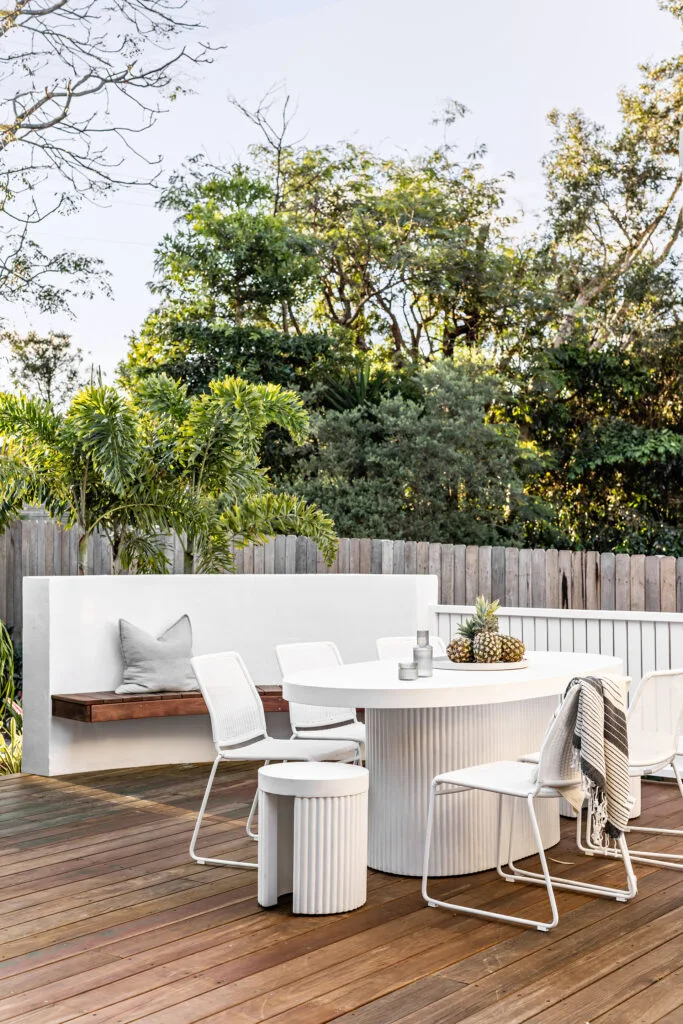 Coastal outdoor dining area with curved furniture