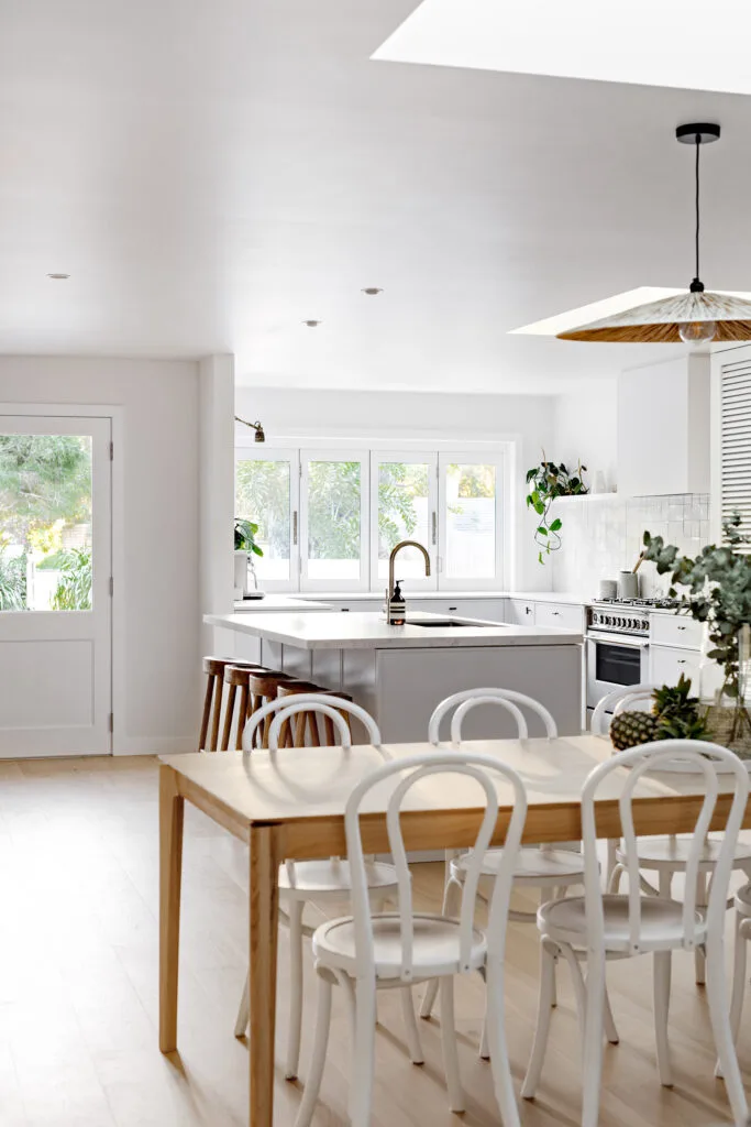 Open plan kitchen and dining room in a beach house.