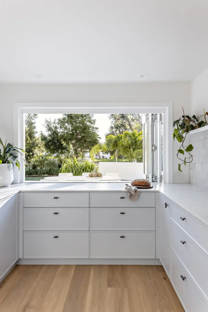 Pale blue beach house kitchen with servery window.