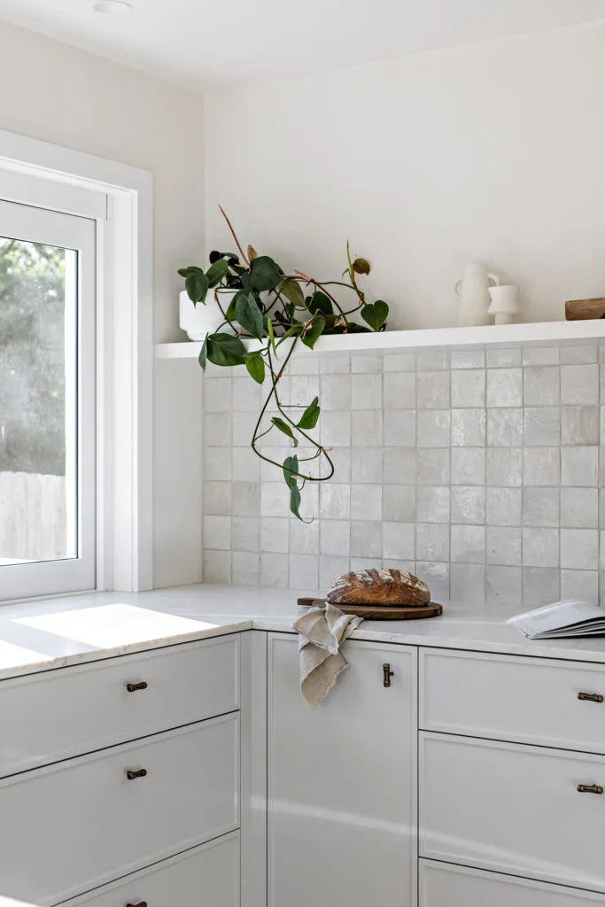 Blue and white coastal kitchen with square-tiled splashback.