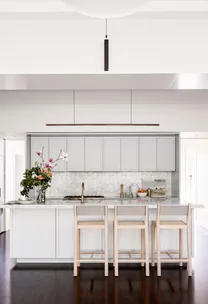 Kitchen with grey cabinetry and a vase of flowers on the island.