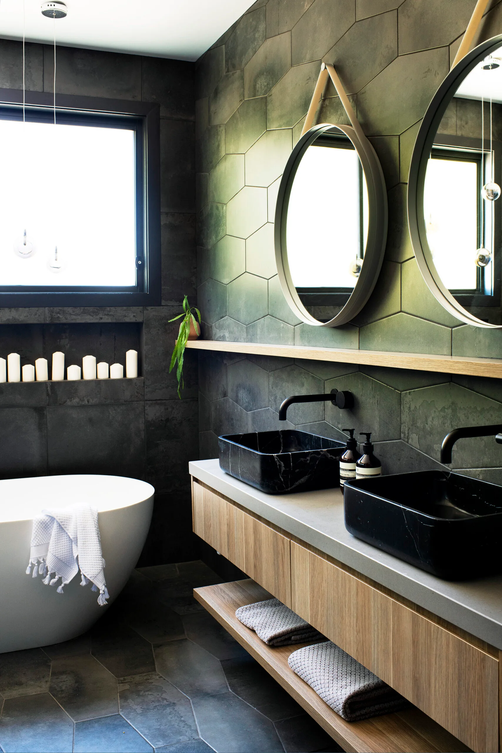 A green tiled bathroom with a row of candles
