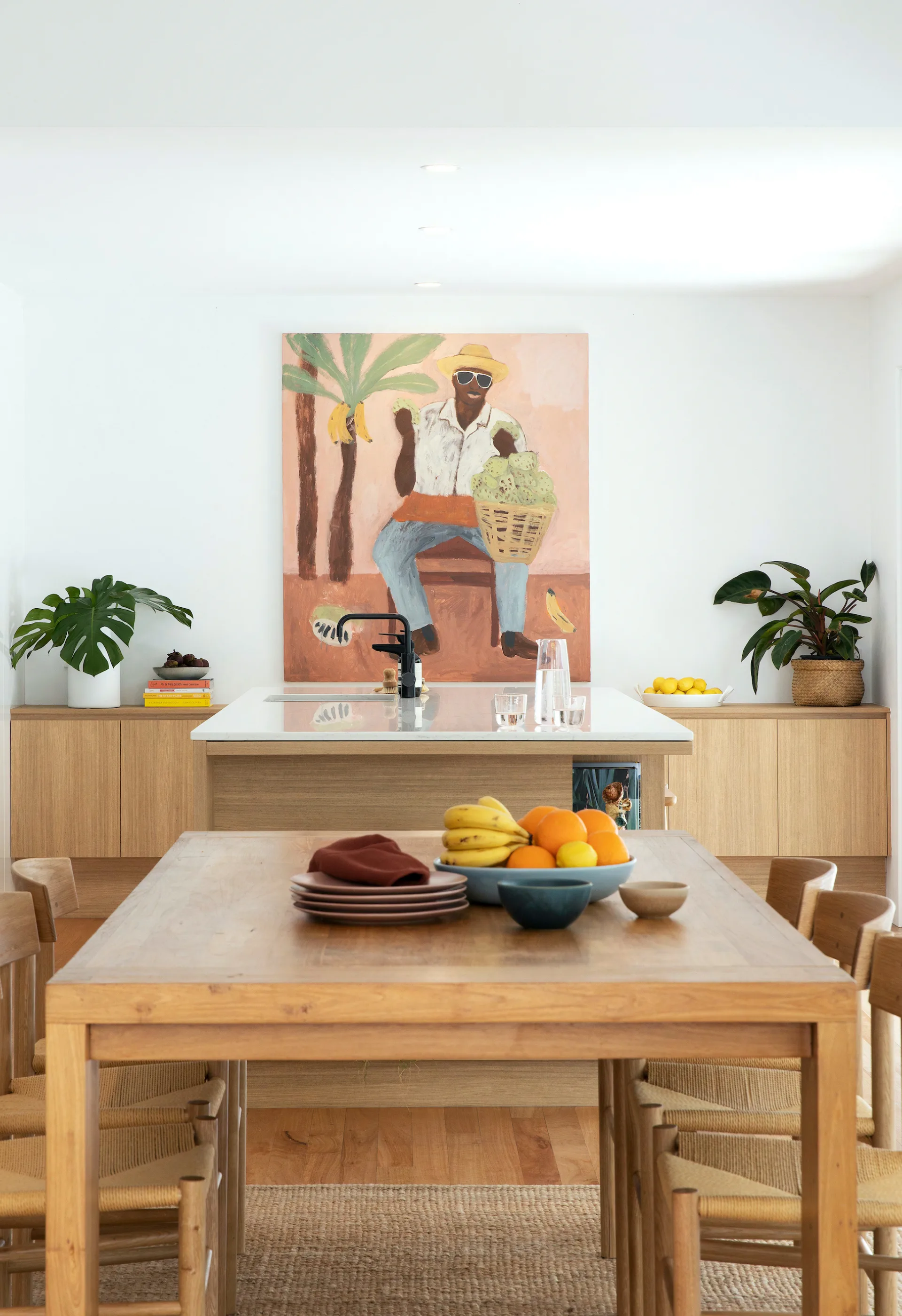 A clean kitchen and dining area with plates on the table.