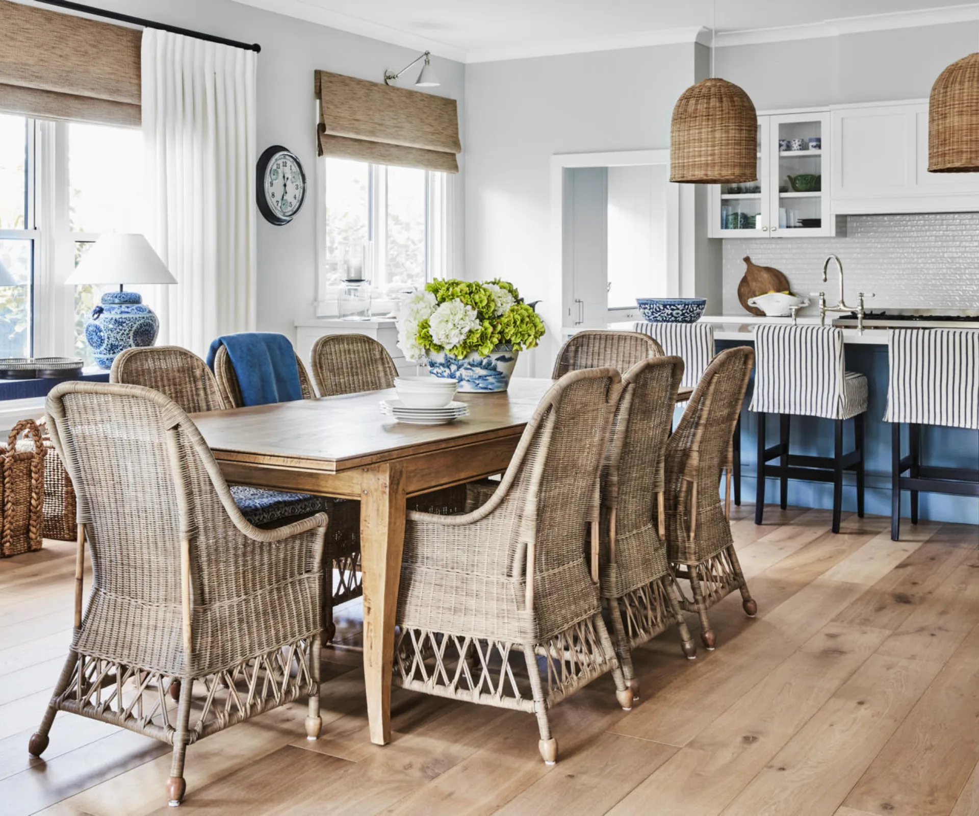 The dining room in a Bowral cottage with woven chairs, blinds and pendant.