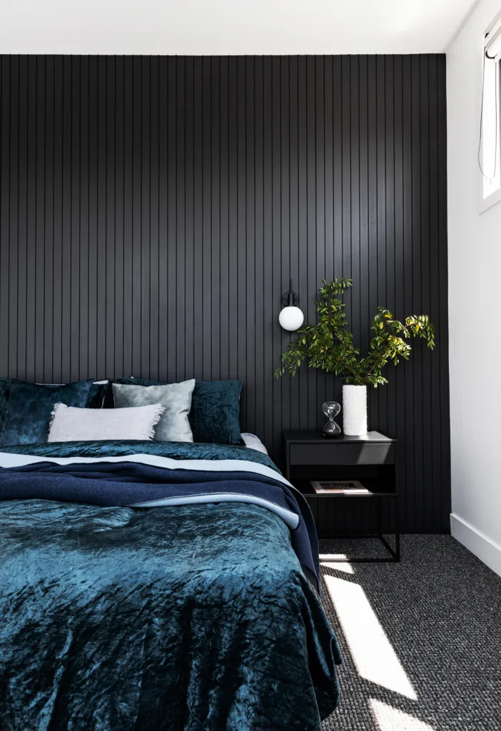 Black painted, timber panelled feature wall in bedroom