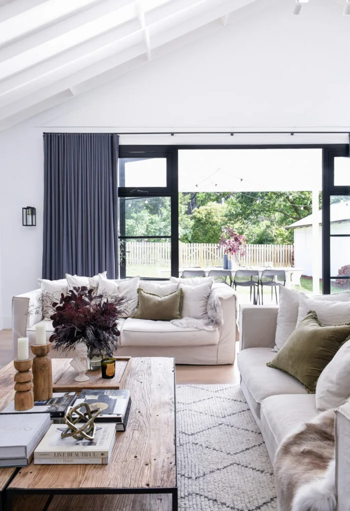 A neutral rug with a black geometric pattern sits atop wooden floors