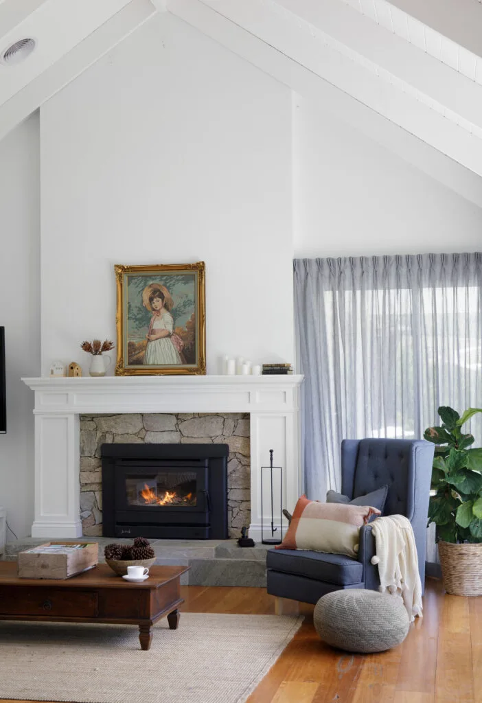 Living room with pitched ceiling and fireplace with natural stone surround