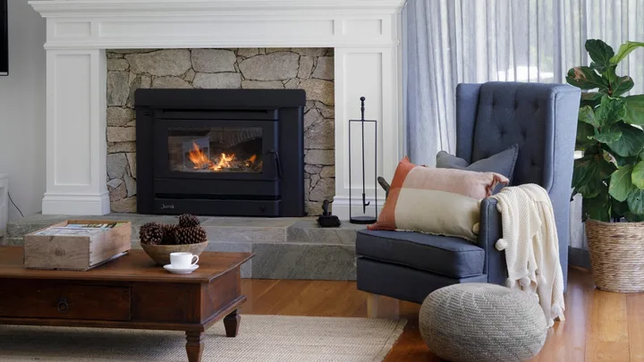 Living room with pitched ceiling and fireplace with natural stone surround
