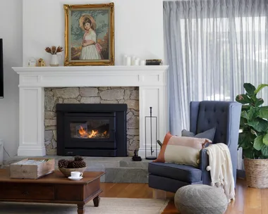 Living room with pitched ceiling and fireplace with natural stone surround