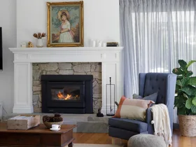 Living room with pitched ceiling and fireplace with natural stone surround