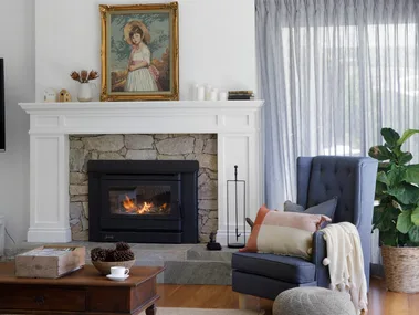 Living room with pitched ceiling and fireplace with natural stone surround