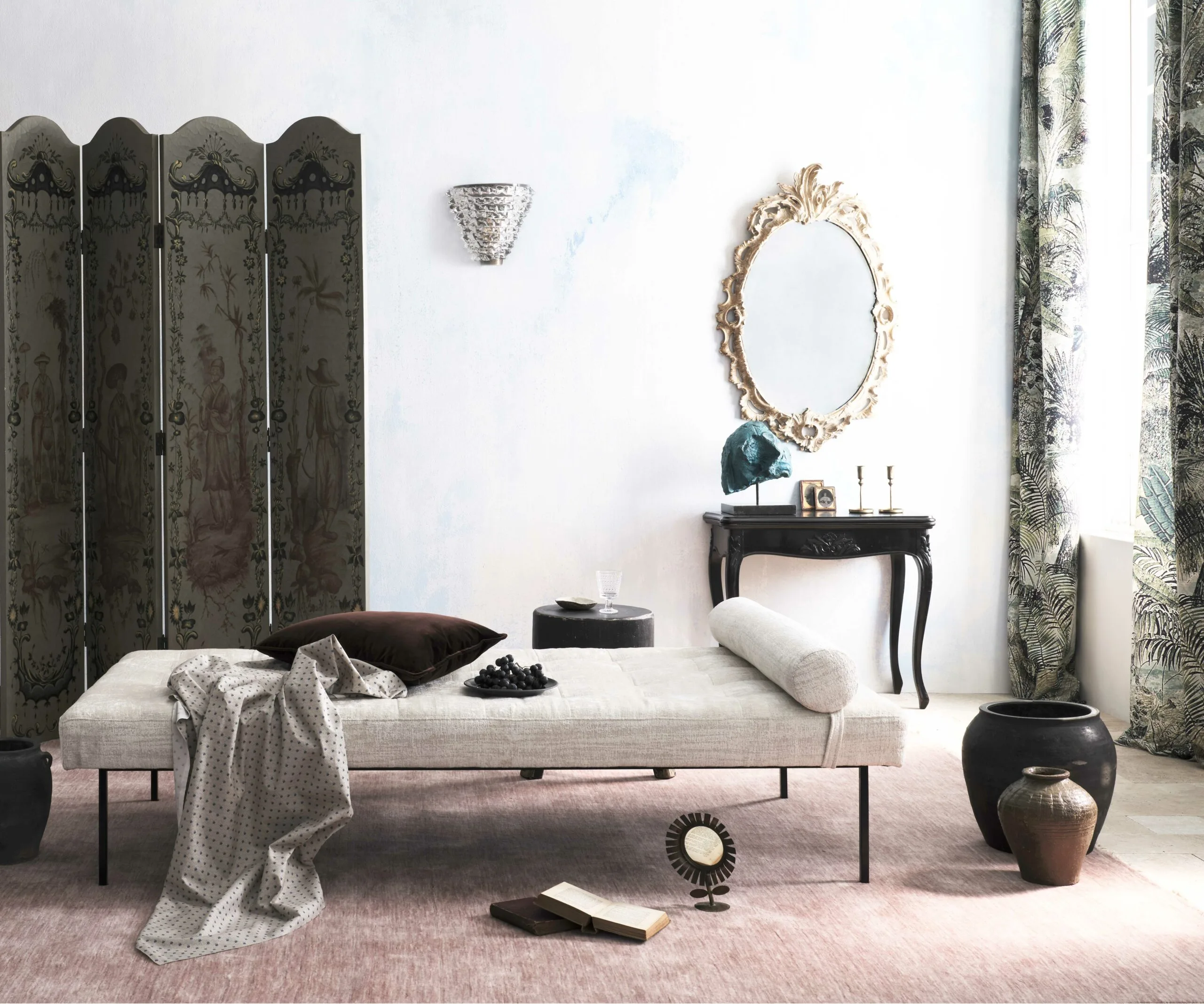 Elegant living room with a chaise longue, ornate mirror, decorative screen, and various decor items arranged tastefully.