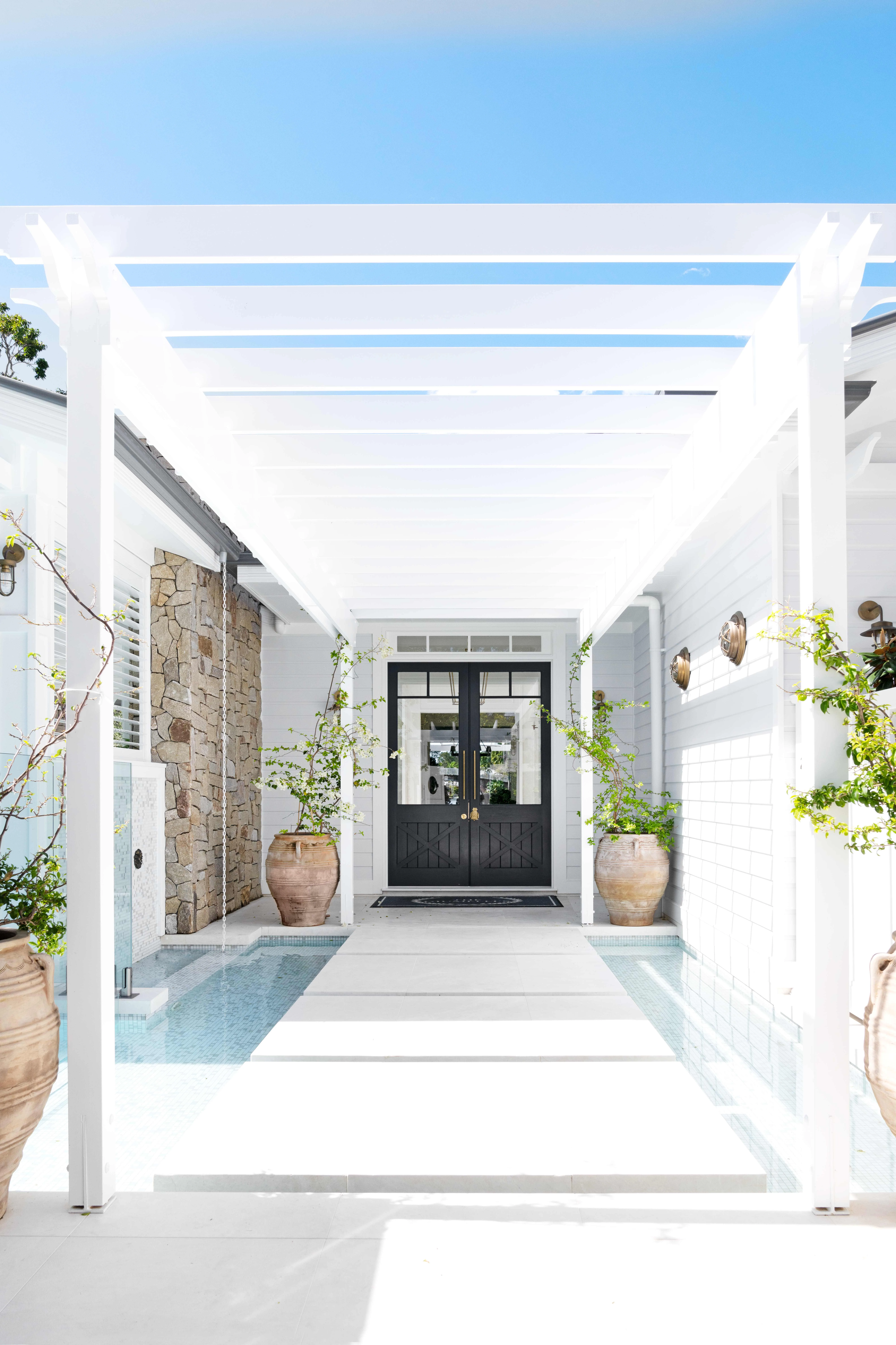 double front door in grand Hamptons home entrance over water feature