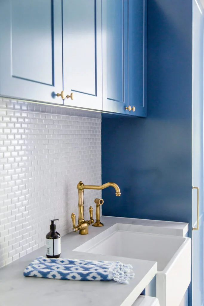 White and blue laundry with a ceramic farmhouse sink.