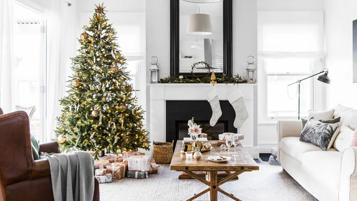Christmas tree and decorations in a cozy living room with a fireplace, stockings, and a coffee table with gifts.