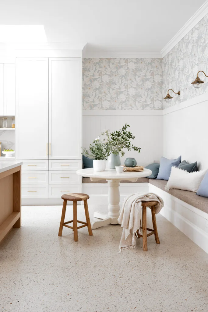 A breakfast nook with banquette seating and two timber stools