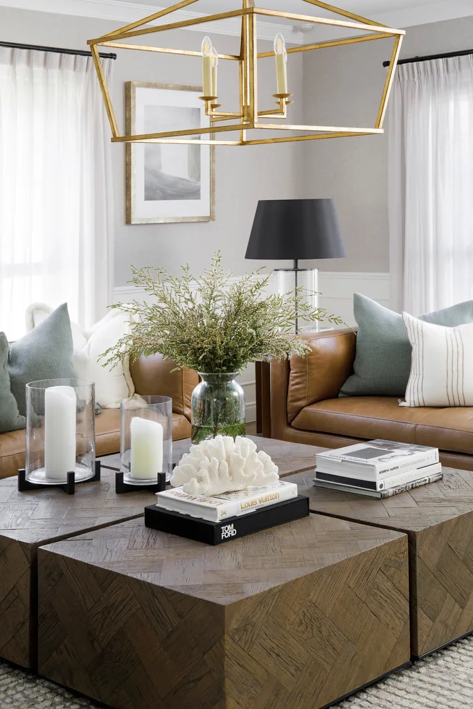 Glam living room with brown leather sofas and large timber coffee table.