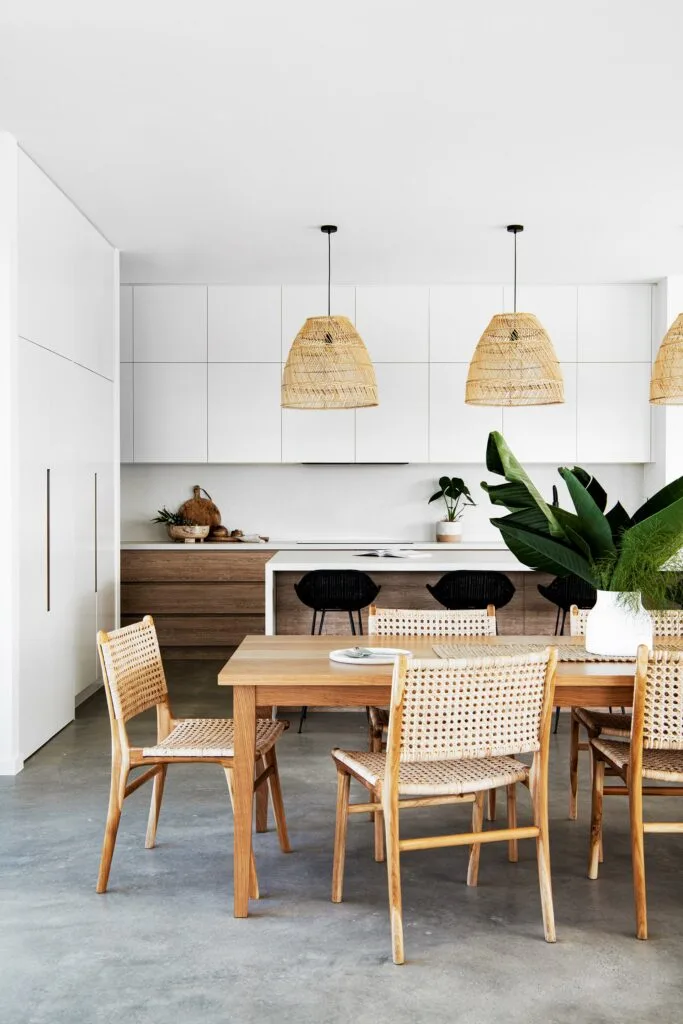 Coastal style modern kitchen design with rattan pendant light and open plan dining room