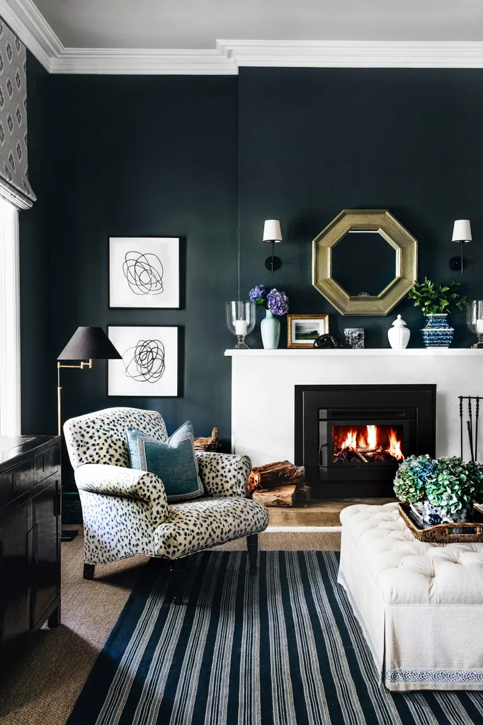 Cozy living room with a patterned armchair, elegant fireplace, abstract art, and decorative items on mantel.