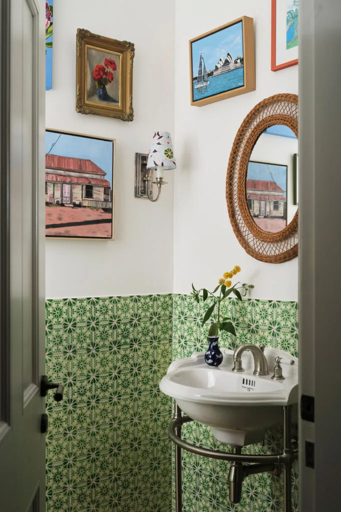 Eclectic powder room ideas with gallery style artworks and patterned tiles as wainscoting