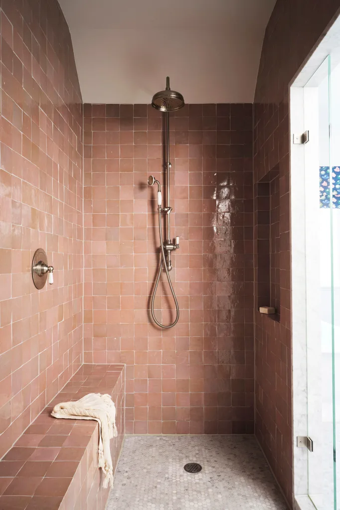 pink tiled shower with in-built seating shelf