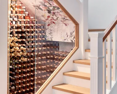 A wine cellar located under a staircase.