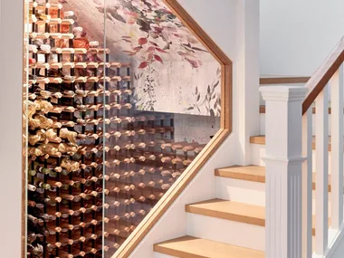 A wine cellar located under a staircase.