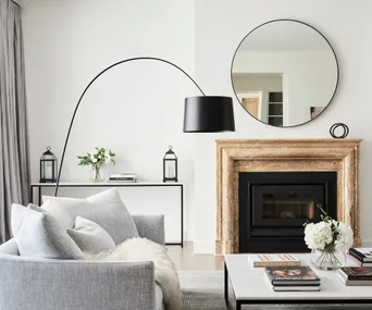 Living room with fireplace and large circular mirror