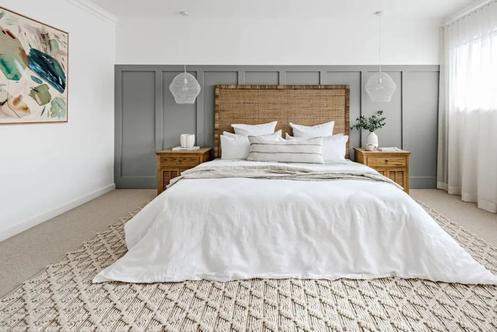 Large bedroom with rattan bedhead, white linen and a plush rug