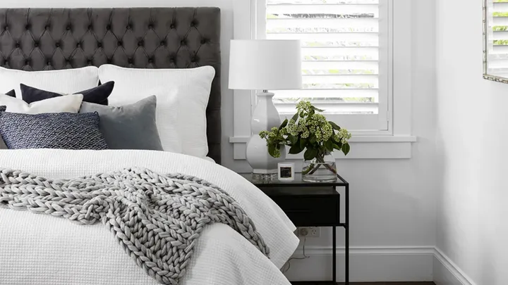 Black and white Hamptons style bedroom with warm waffle quilt on the bed.