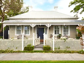 A heritage home with a white facade and picket fence.