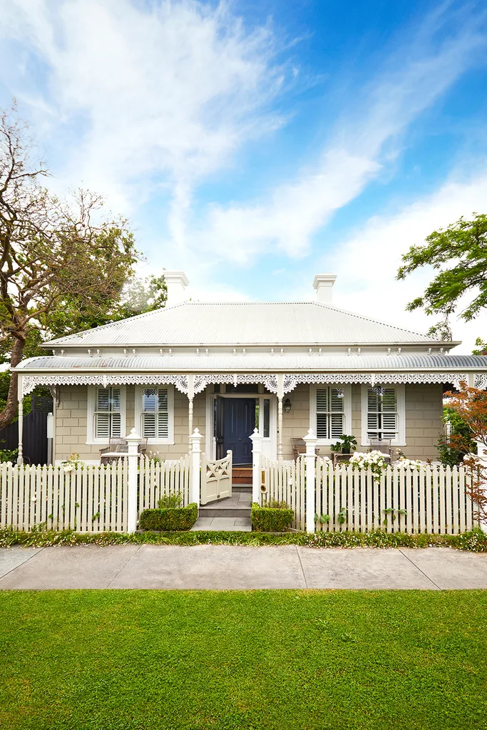 A heritage home with a white facade and picket fence.