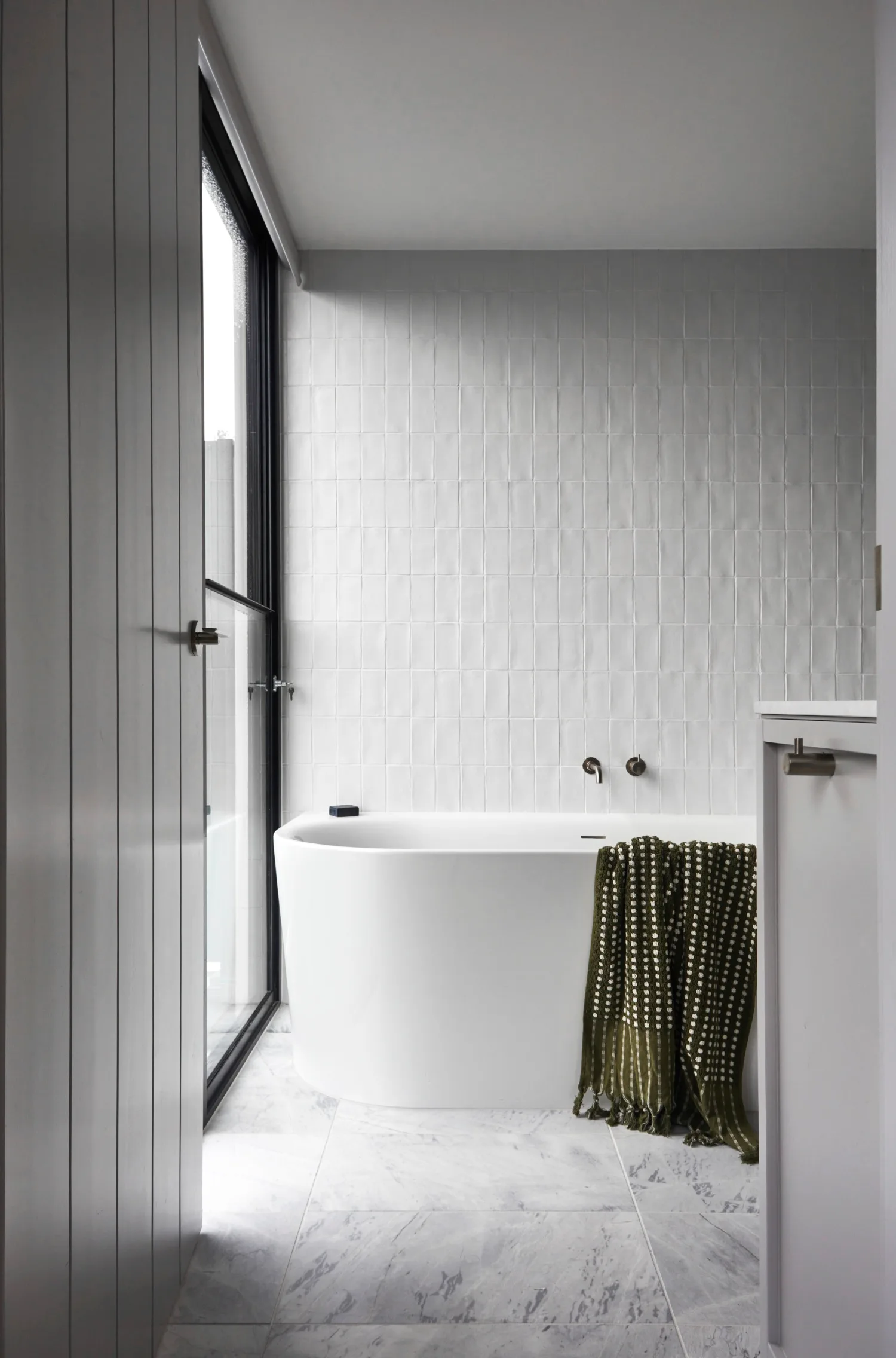 ensuite with white wall tiles and grey marble floor