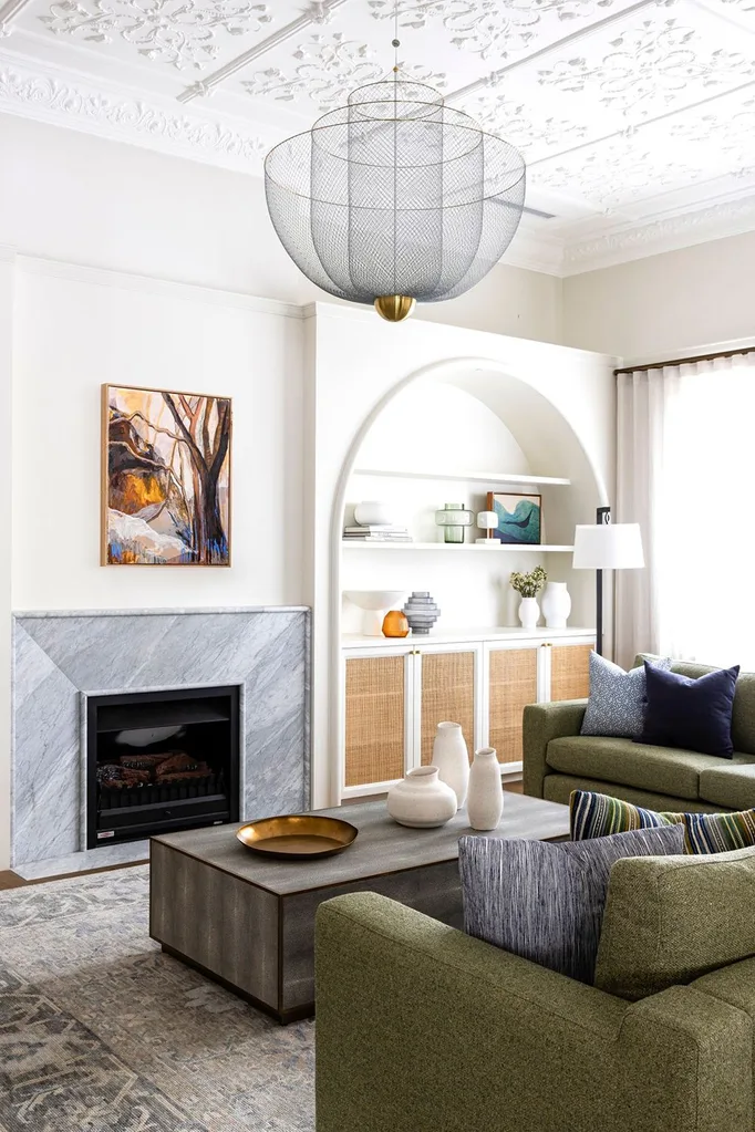 Marble fireplace next to curved book shelf