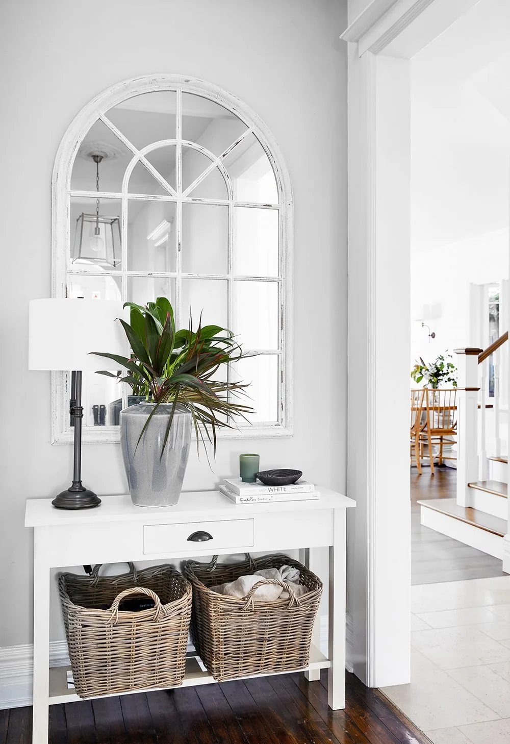 Hamptons entryway with mirror and wicker storage baskets