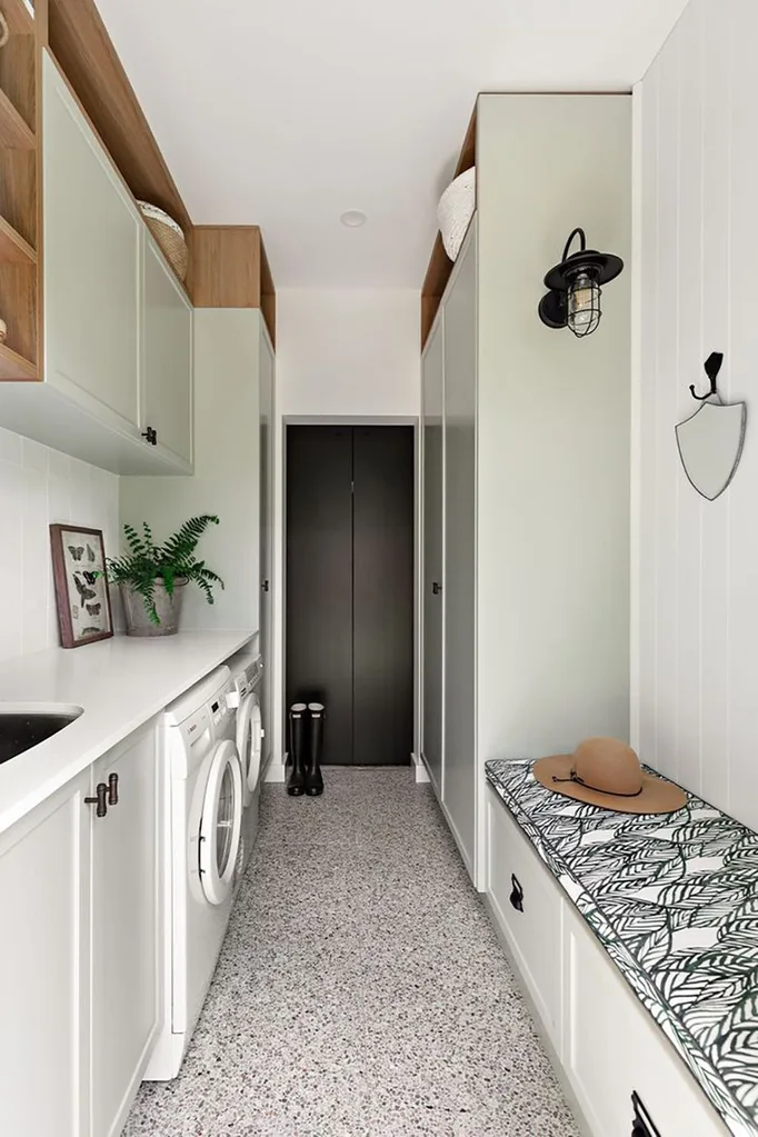 Green laundry and mudroom combination with terrazzo flooring