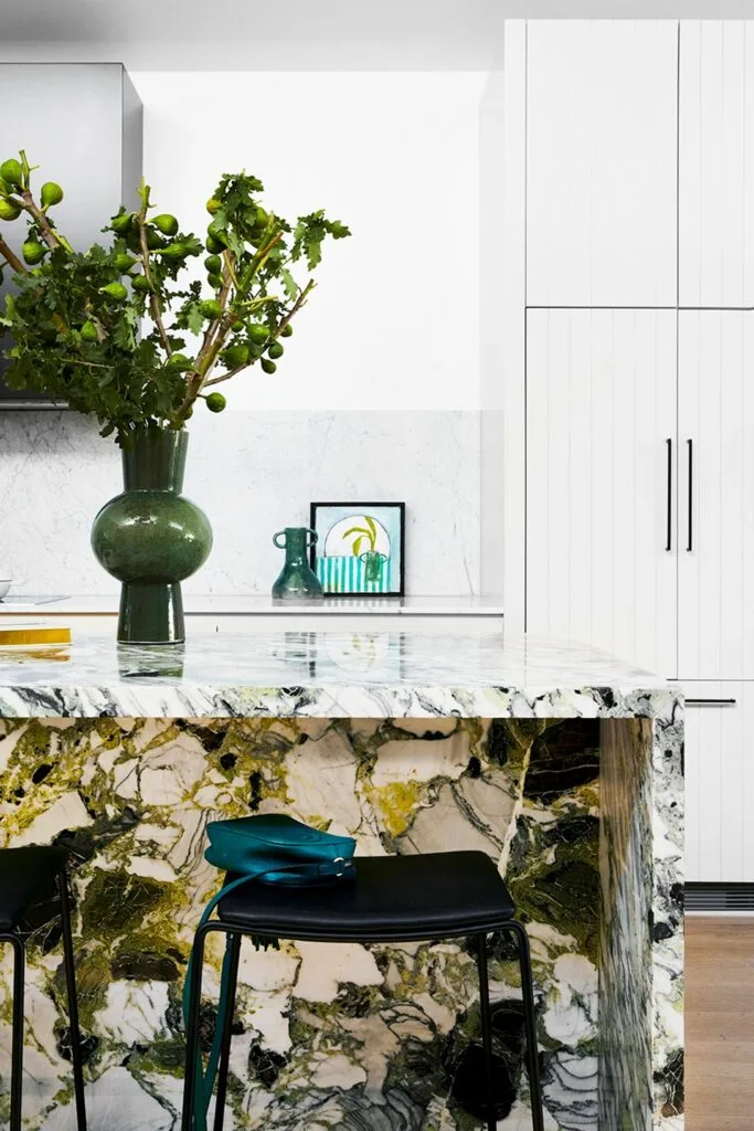 Modern kitchen with green marble waterfall island bench and grooved kitchen cabinet doors