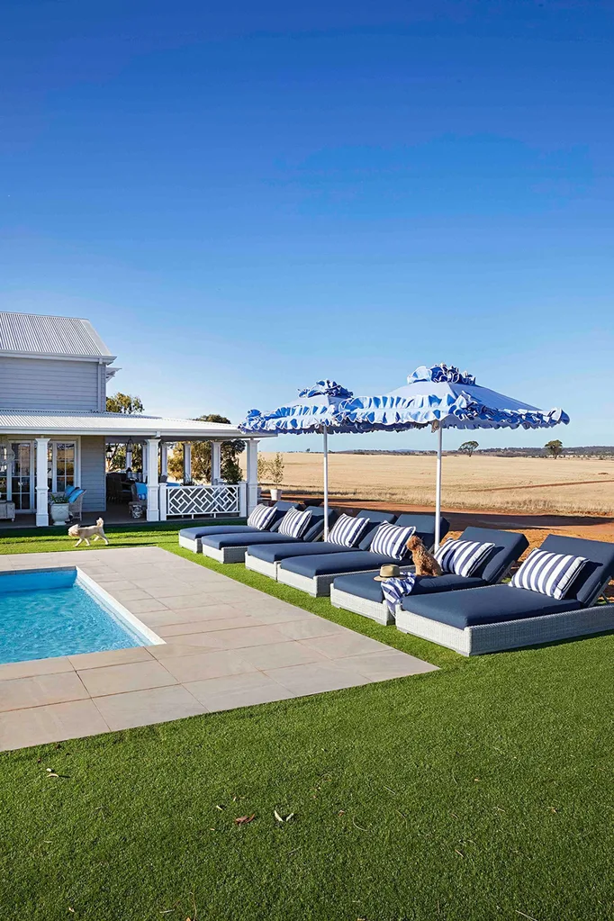 Hamptons style pool area with navy sun loungers