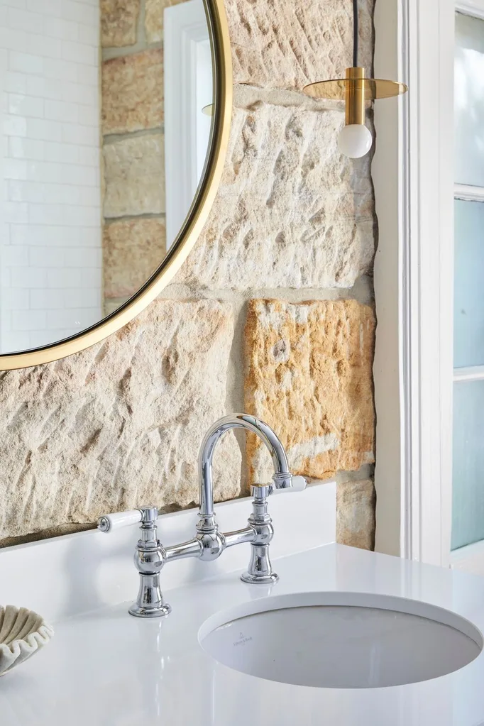 heritage bathroom renovation with sandstone wall and silver tapware