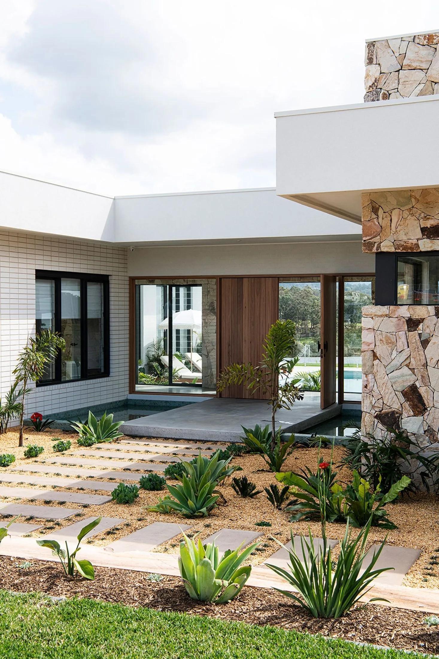 Midcentury-inspired house with stepping stone and gravel pathway