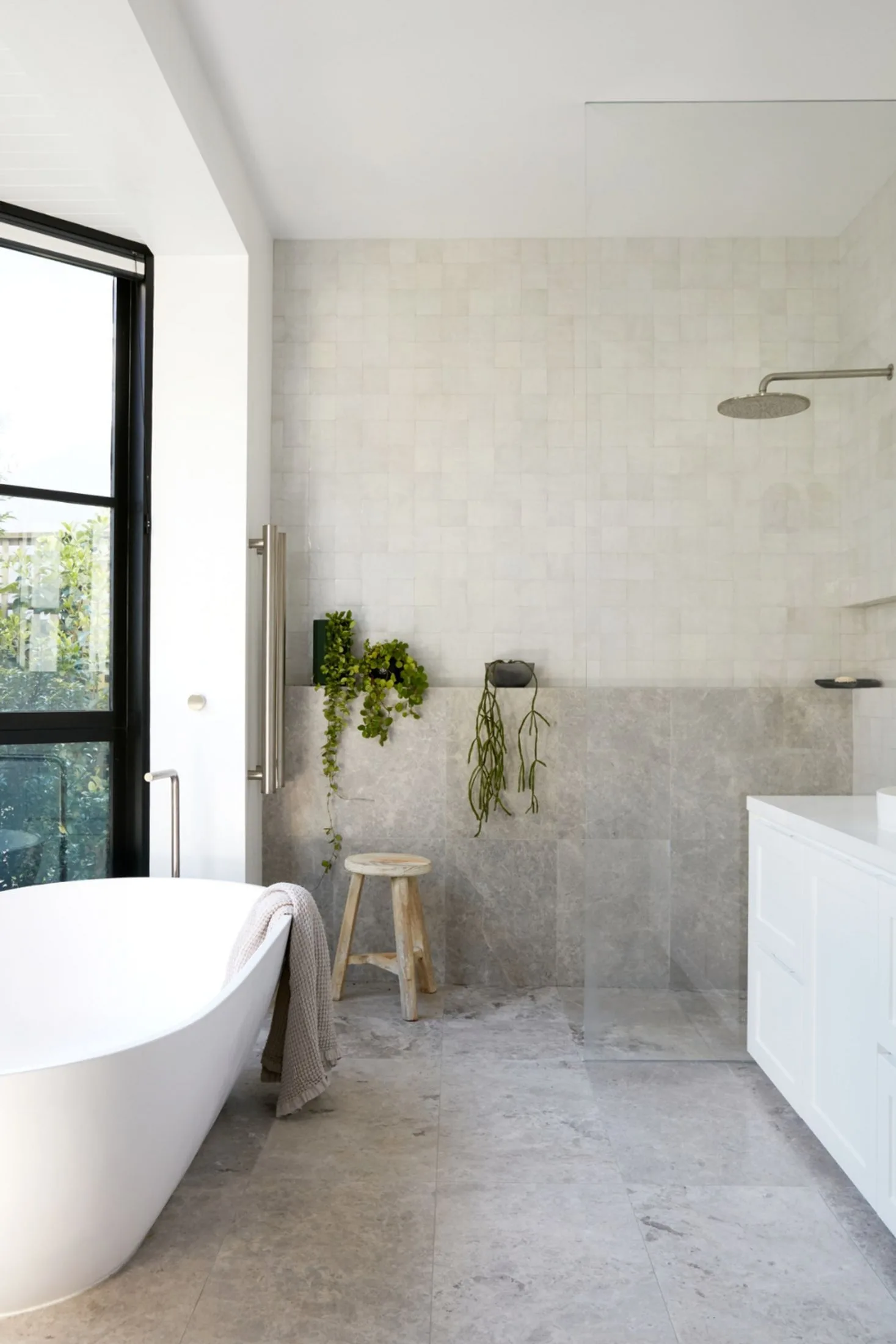 Grey limestone ensuite bathroom with a freestanding bath and display ledge