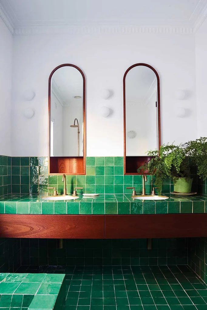 Luxury bathroom with green tiles and arched mirrors