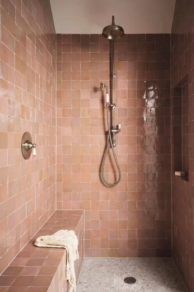 Pink tiled bathroom shower with brass tapware