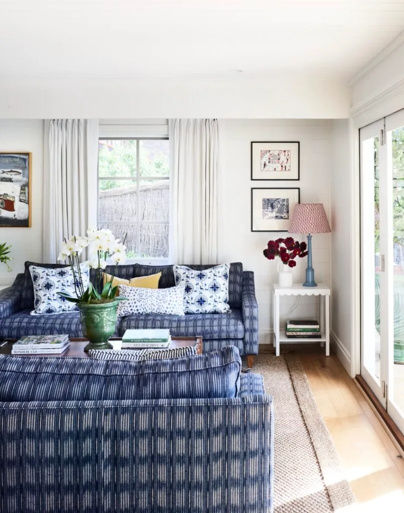 Light living room with sisal rug and blue and white sofa