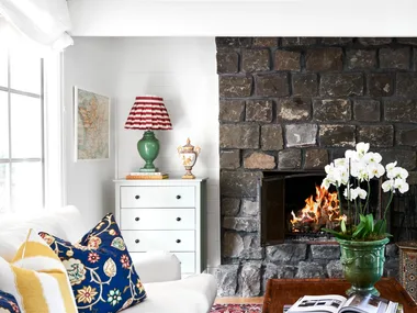 Light living room with white sofa and stone fireplace